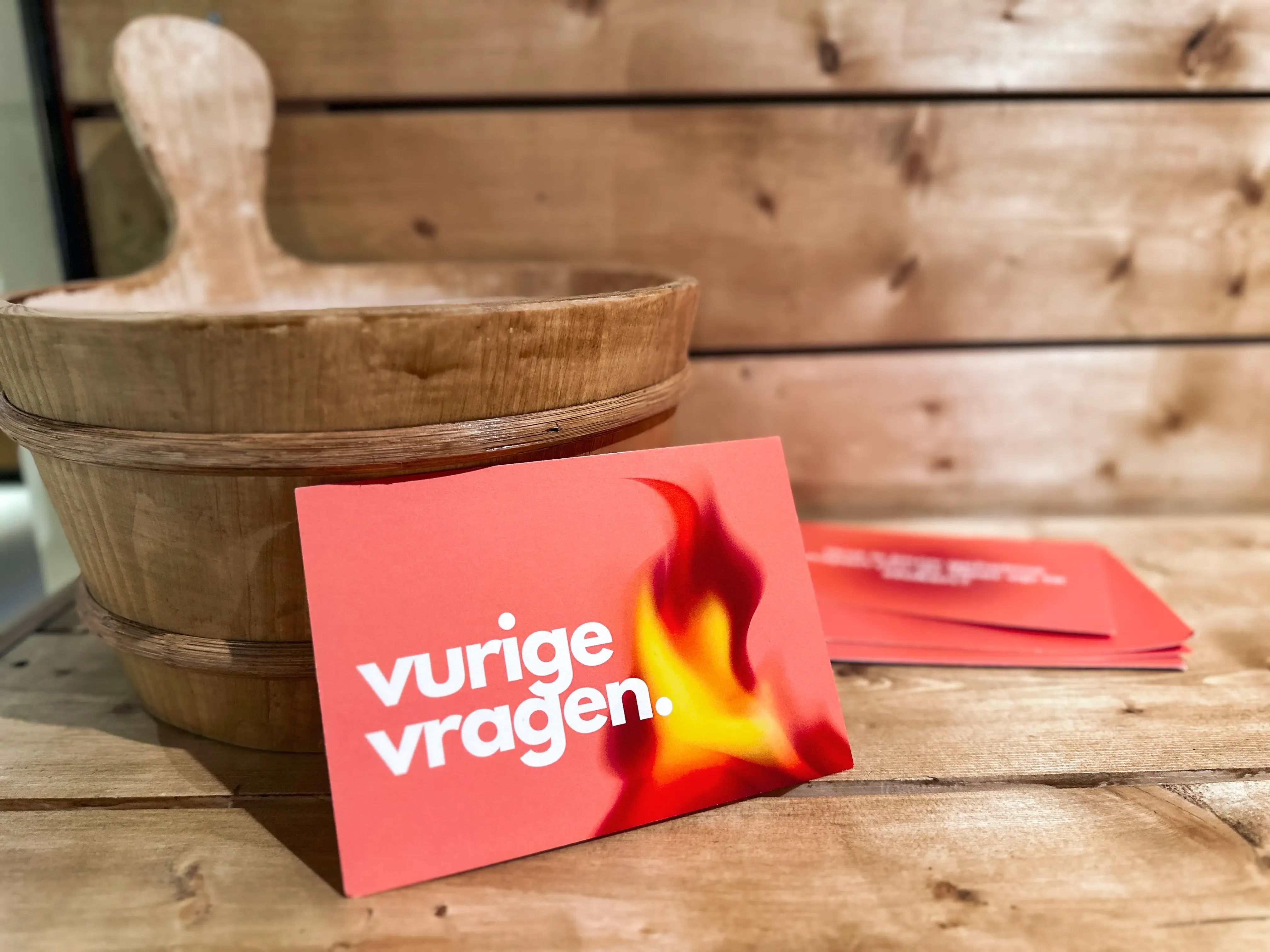 Rode kaart met ‘vurige vragen’ en vlam naast een opgietingsbak