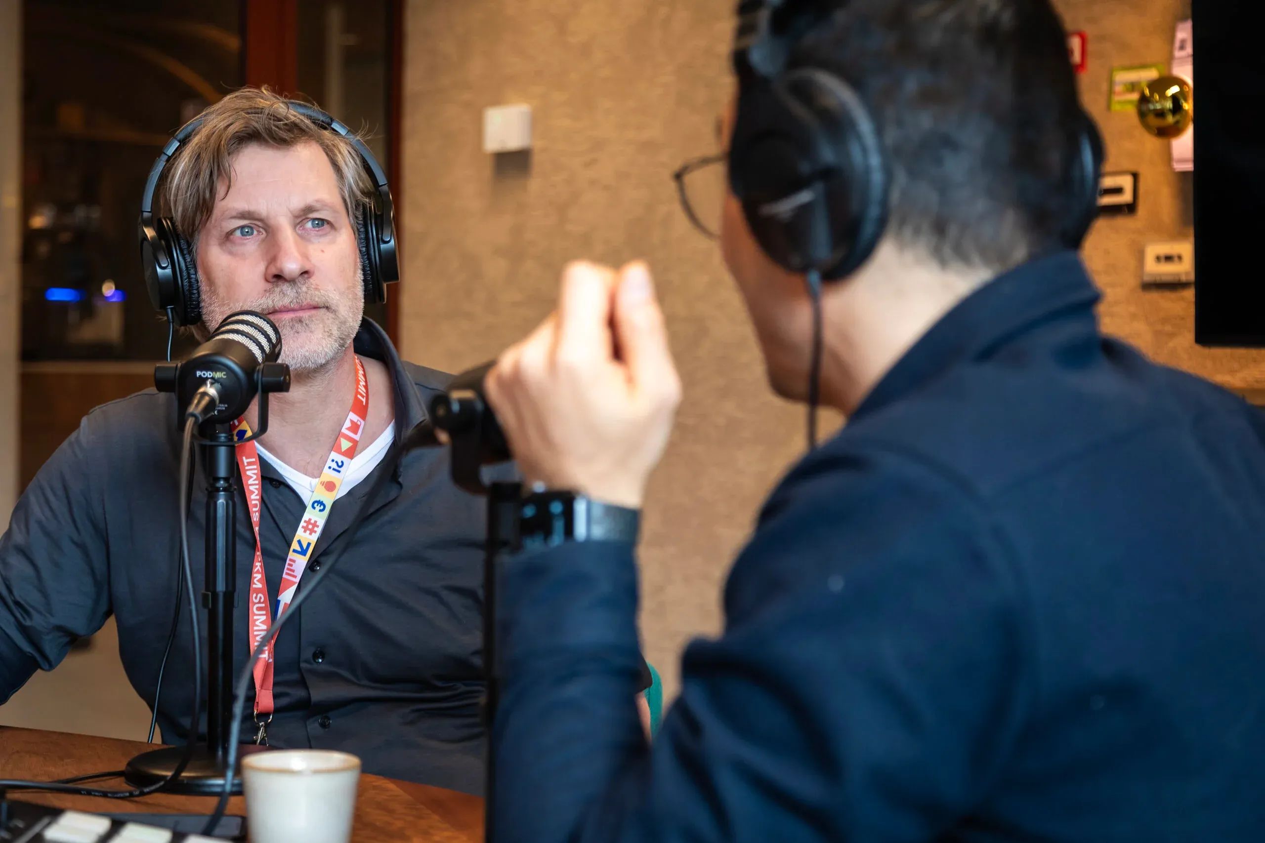 Twee mannen nemen een podcast op en kijken serieus 